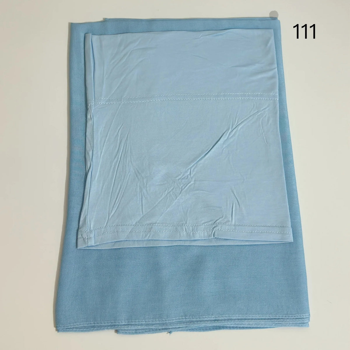 A light blue soft modal rayon hijab set folded and displayed flat.