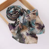 Foulard hijab imprimé élégant roulé, tons doux de bleu, violet et beige.
