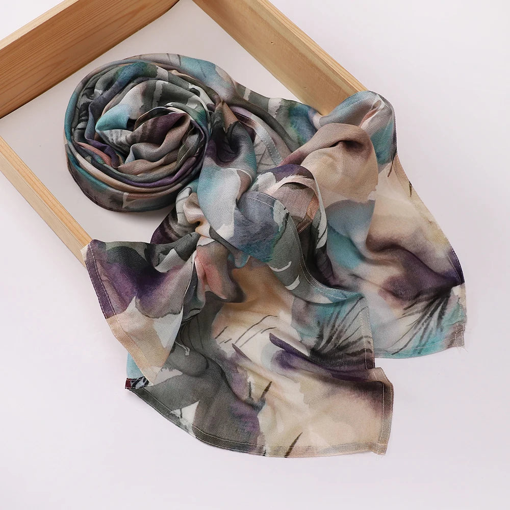 Foulard hijab imprimé élégant roulé, tons doux de bleu, violet et beige.