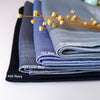 Ein Stapel aus gerüschtem Satin-Chiffon-Hijabs in verschiedenen Farben wie Stahlgrau, Blau und Marineblau mit getrockneten ge