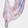 A flowing, light pink and blue floral printed linen hijab scarf draped elegantly.