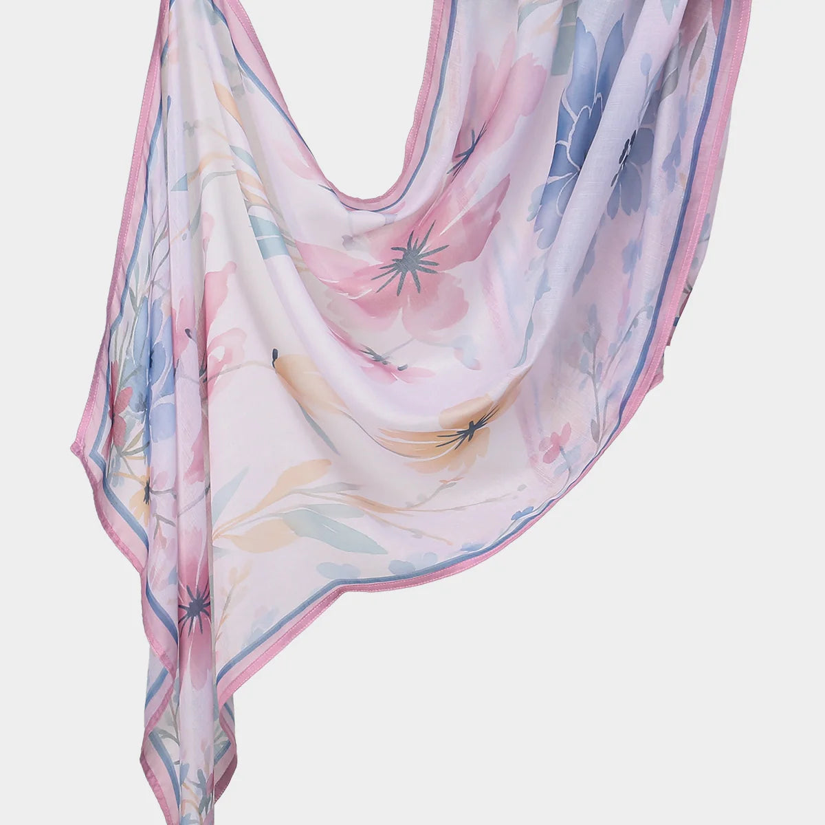 A flowing, light pink and blue floral printed linen hijab scarf draped elegantly.