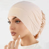 Eine Frau trägt eine beige Stretch-Turbanmütze, im Profilansicht dargestellt.