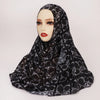 Un pañuelo de hijab negro con estampado de leopardo mostrado en un maniquí de cabeza.