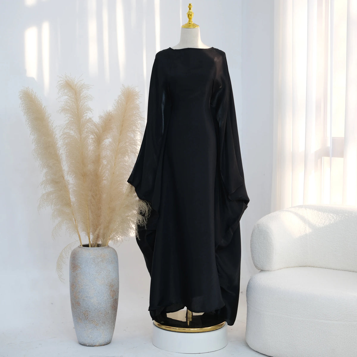 Schwarzes, elegantes Kaftankleid mit Schmetterlingsärmeln auf einem Mannequin.