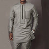 Un homme portant un costume de mariage musulman traditionnel africain gris clair avec des détails verticaux et rectangulaires