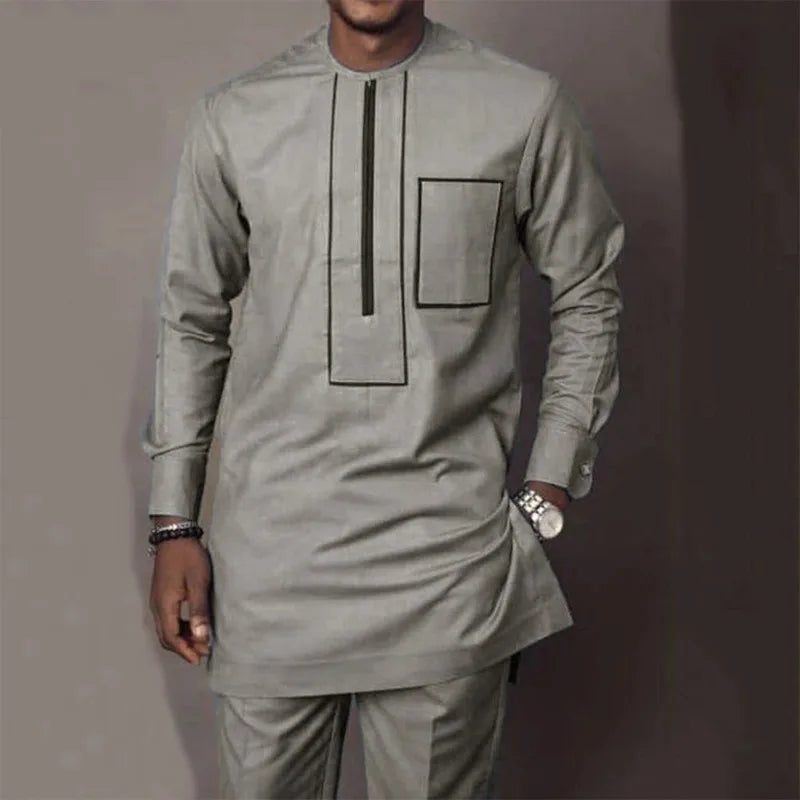 Un homme portant un costume de mariage musulman traditionnel africain gris clair avec des détails verticaux et rectangulaires