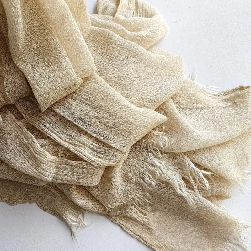 Gros plan d'un foulard hijab en coton viscose beige avec des bords froncés et des pompons