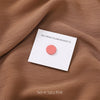Set of four pink no-snag hijab magnets on a brown fabric background