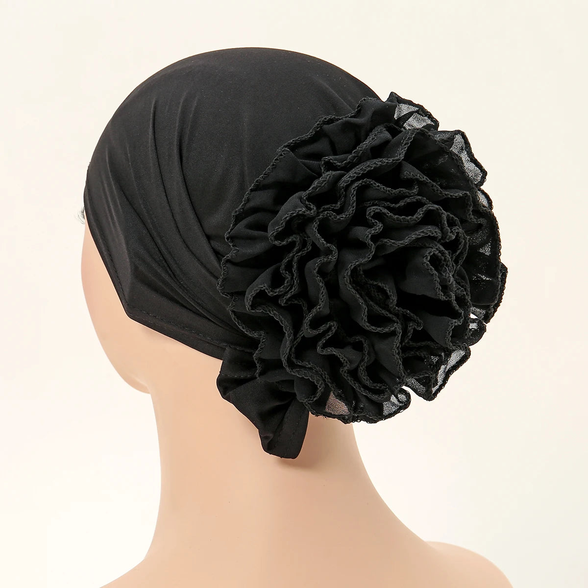 Schwarzer Spitzenblumen-Volumizer-Hijab-Kappe auf einem Mannequin.