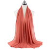 A flowing coral chiffon hijab scarf draped around a mannequin's neck.