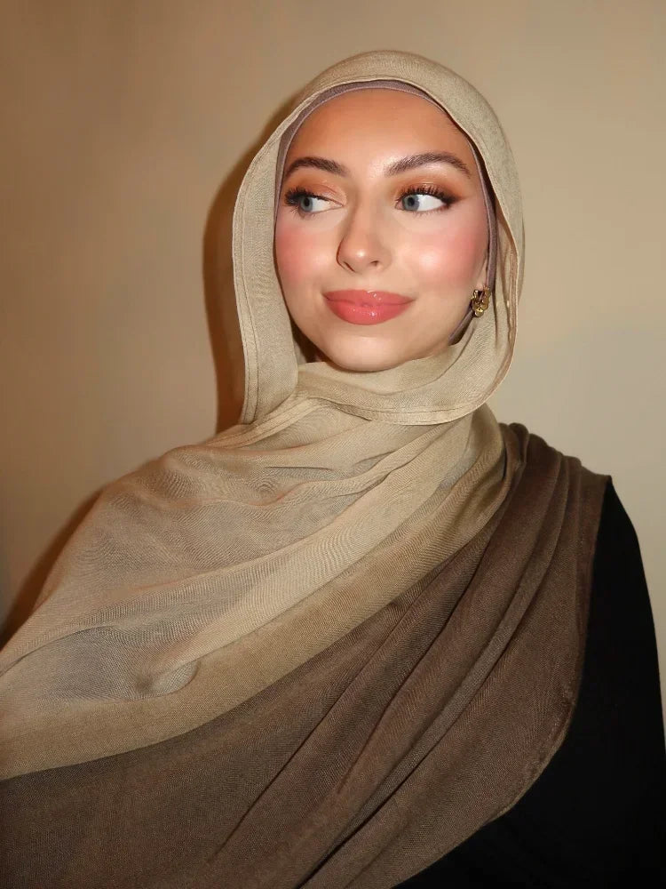 Eine Frau trägt einen beige-gradienten Rayon-Modal-Hijabschal über Kopf und Schultern.