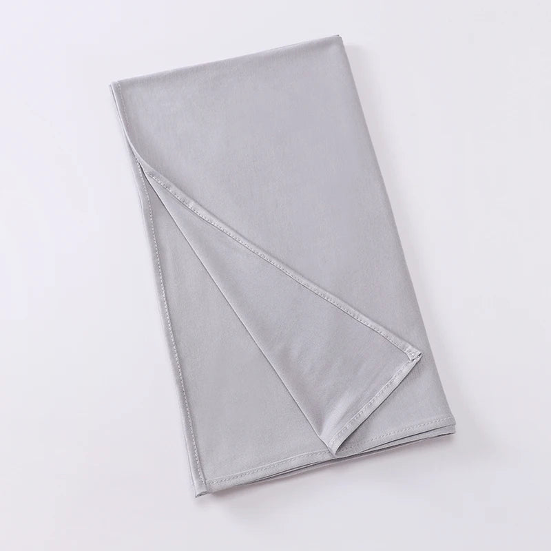 Foulard instant en jersey gris clair et extensible, plié et exposé sur fond blanc.