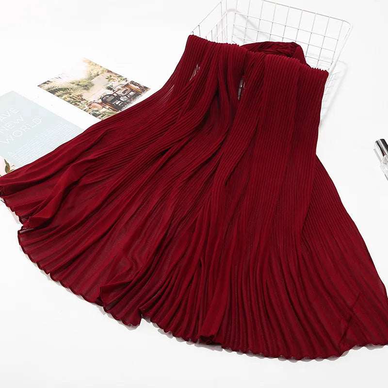 Tiefmaroniges Crinkle-Chiffon-Hijab-Tuch, drapiert und gefaltet auf weißem Untergrund.