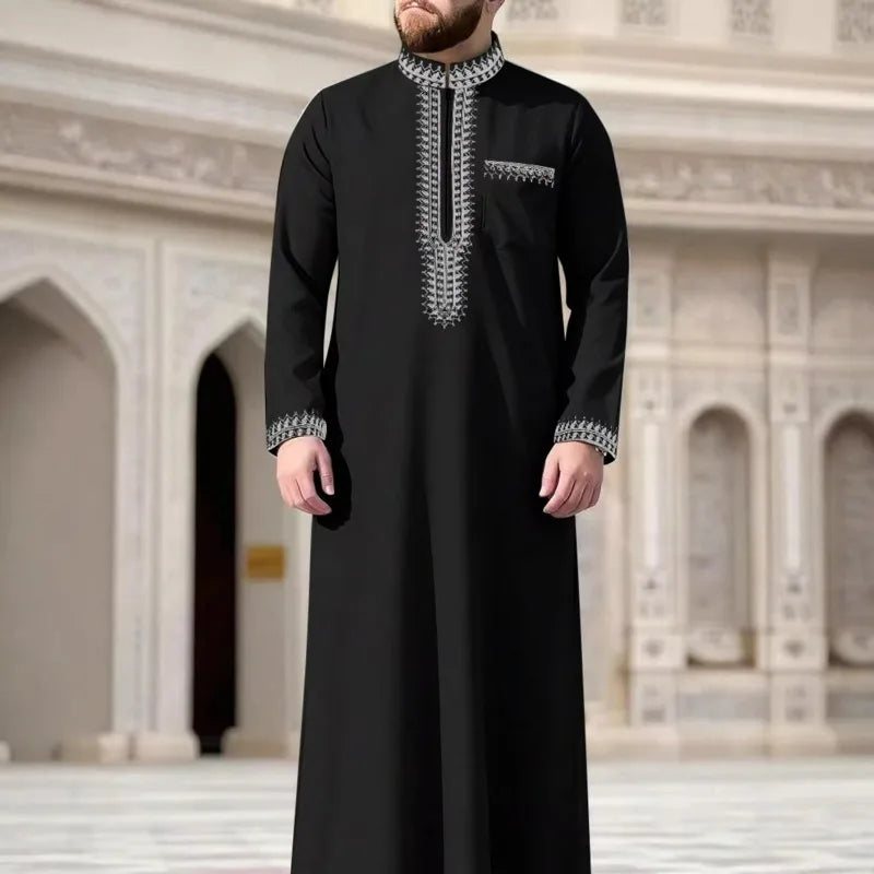 Jubba thobe casual robe for men, embroidered in black with silver detailing, standing in a grand architectural setting.