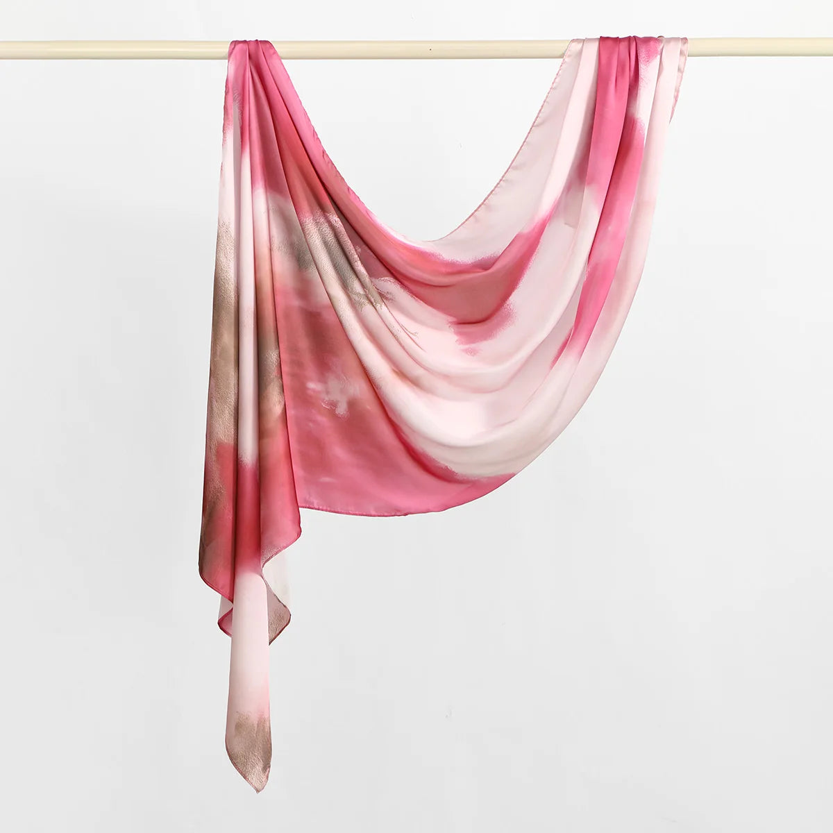 Rosa und beige bedrucktes Seidenschal-Hijab über einer Wäscheleine getragen.