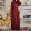Una mujer vistiendo una túnica de abaya kaftan islámica larga color granate en un entorno formal.