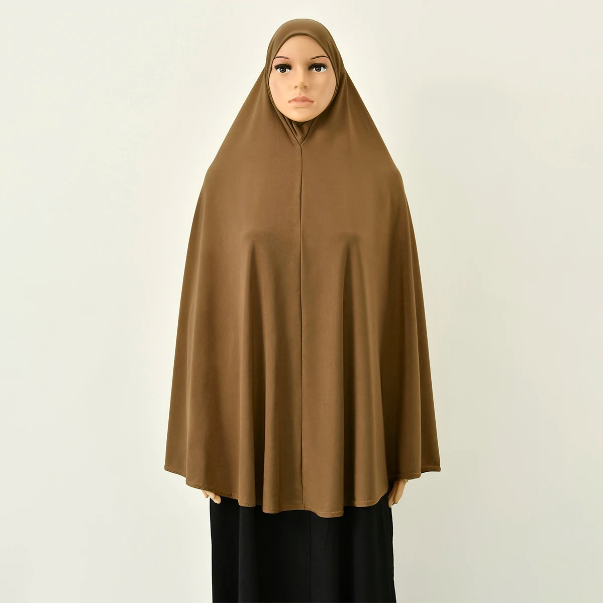 Eine Frau trägt eine b മുഴുവättige braune Abaya mit innerer Hijab.