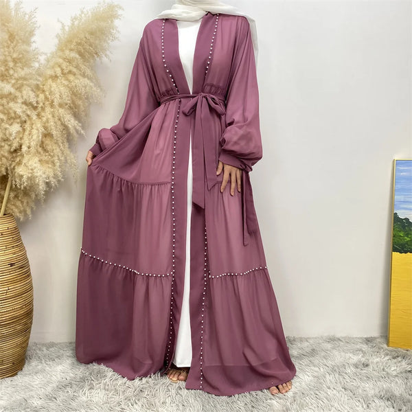 A mauve beaded abaya cardigan robe worn by a model, featuring long sleeves and a tied waist.