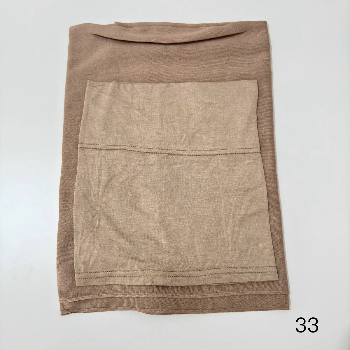 A beige soft modal rayon hijab set folded and displayed on a white background.