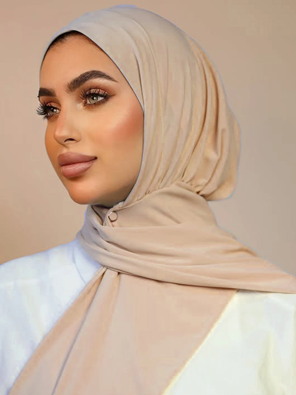 Una mujer vistiendo un hiyab instantáneo beige y ropa blanca.