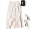 Hellrosa Leinenmisch-Culottes mit weit geschnittenem Bein neben einer schwarzen Clutch und weißen Sandalen