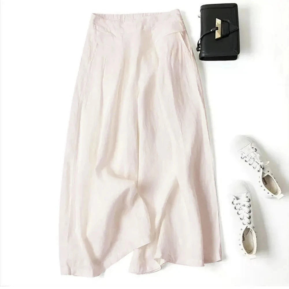 Hellrosa Leinenmisch-Culottes mit weit geschnittenem Bein neben einer schwarzen Clutch und weißen Sandalen