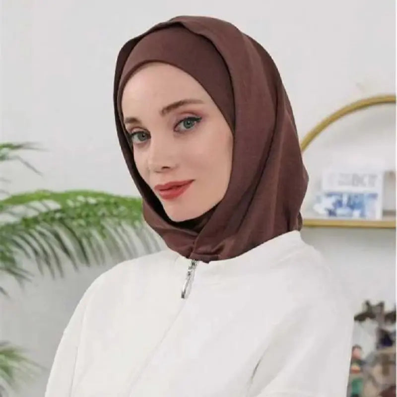 Une femme portant un bonnet hijab instant brun à double couche et un haut blanc.