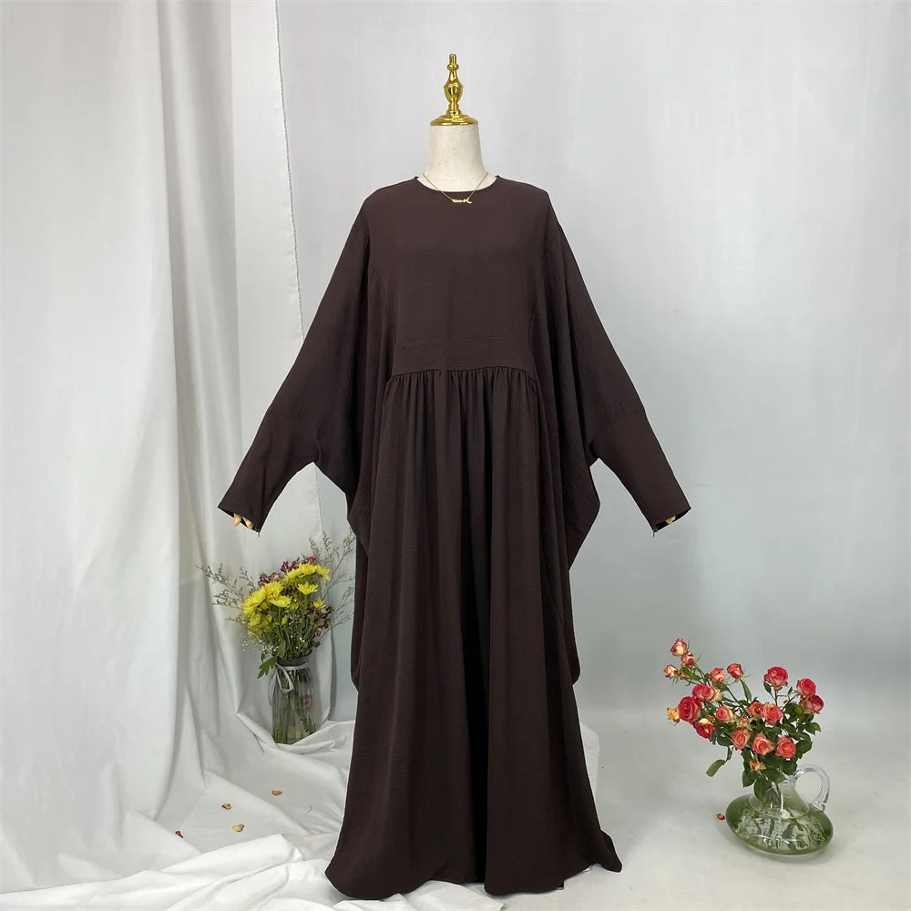 Elegante dunkelbraune Batwing-Abaya auf einem Mannequin vor weißem Hintergrund.