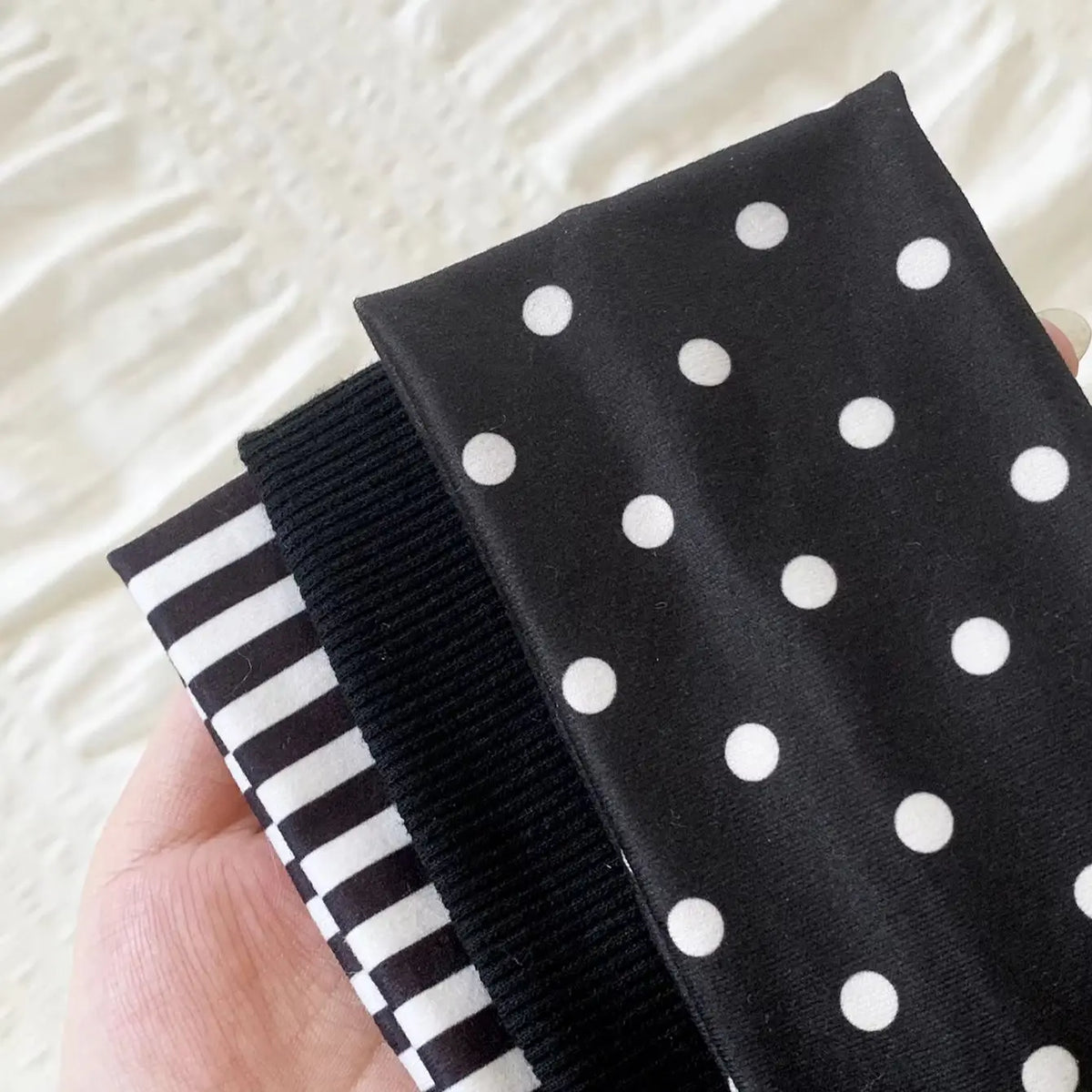 Schwarze Polka-Dot-Haube mit schwarzem Rippstrang und gestreifter Akzent.