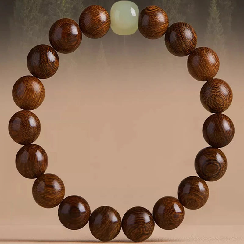 Armband aus dunklen Holzperlen und einem hellgrünen Stein in kreisförmiger Anordnung.