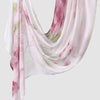 A flowing, sheer pink and white printed linen hijab scarf draped elegantly.