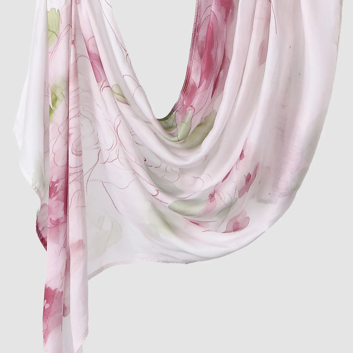 A flowing, sheer pink and white printed linen hijab scarf draped elegantly.