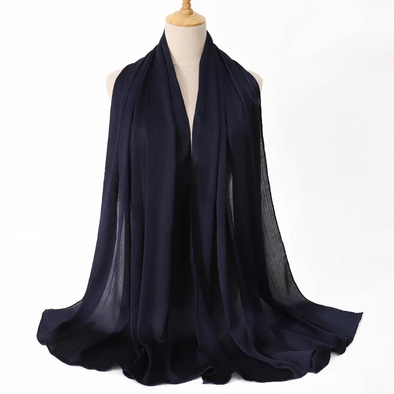 Dunkelblaue Satin-Crinkle-Hijab-Schal über einem Mannequin drapiert.