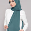 A woman wearing a teal chiffon matching inner scarf set, draped around her neck and shoulders.