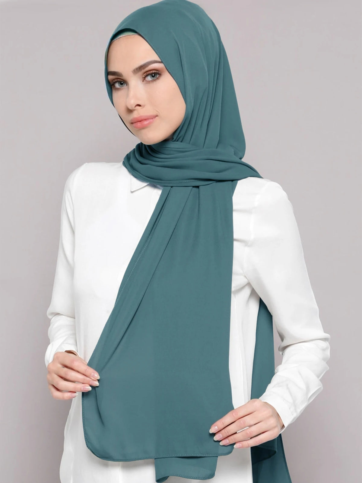 A woman wearing a teal chiffon matching inner scarf set, draped around her neck and shoulders.
