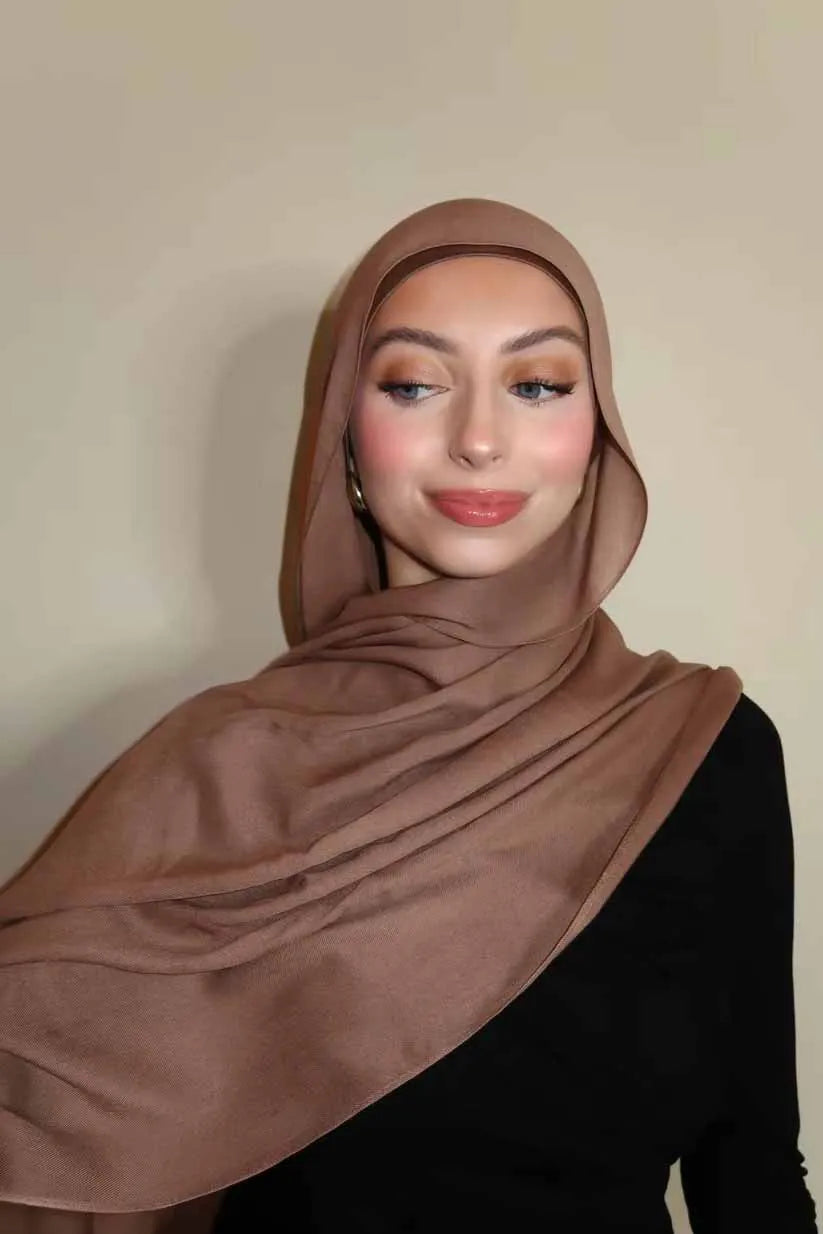 Eine Frau trägt einen braunen Farbverlauf-Rayon-Modalschals und schwarze Kleidung.