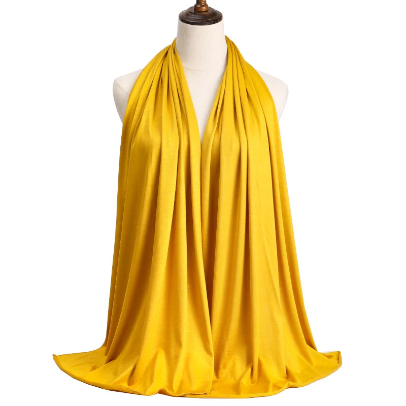 A bright yellow premium modal jersey hijab draped around a mannequin's neck.