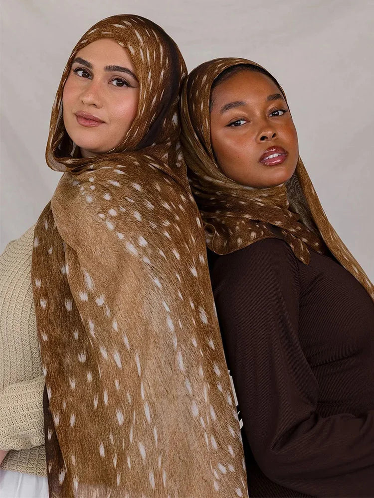 Une femme portant un hijab aquarelle bohème à imprimé léopard marron, regardant directement l'appareil photo.