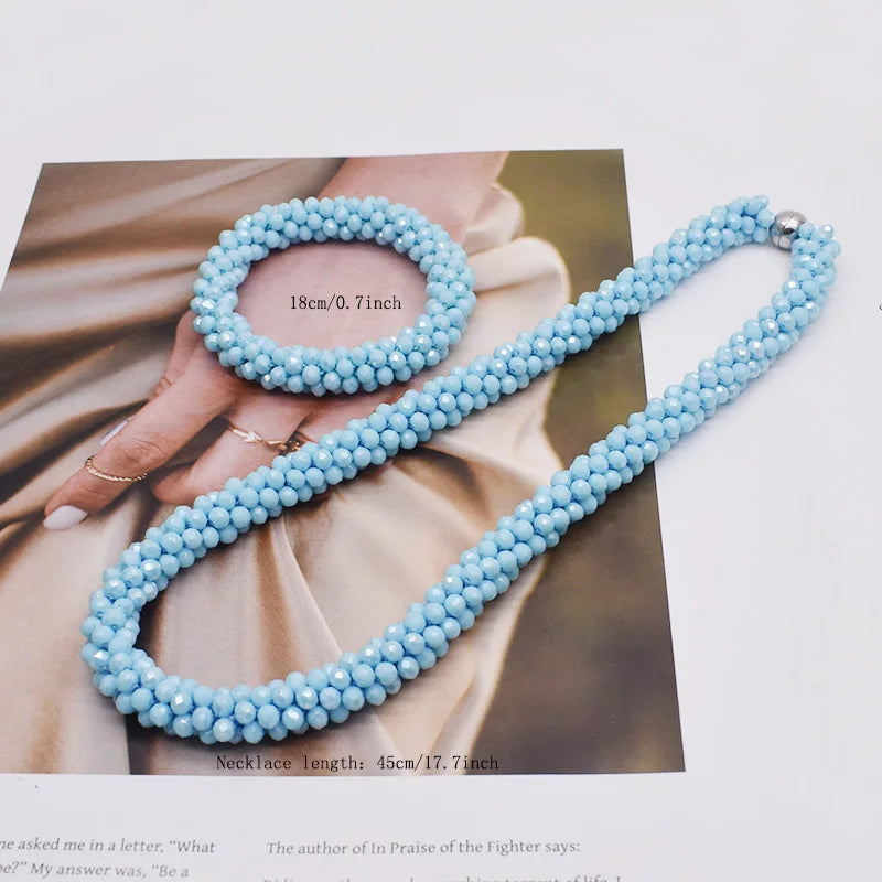 Helles blaues Perlen-Anhänger-Halsband vor Hintergrund mit Hand und Stoff.