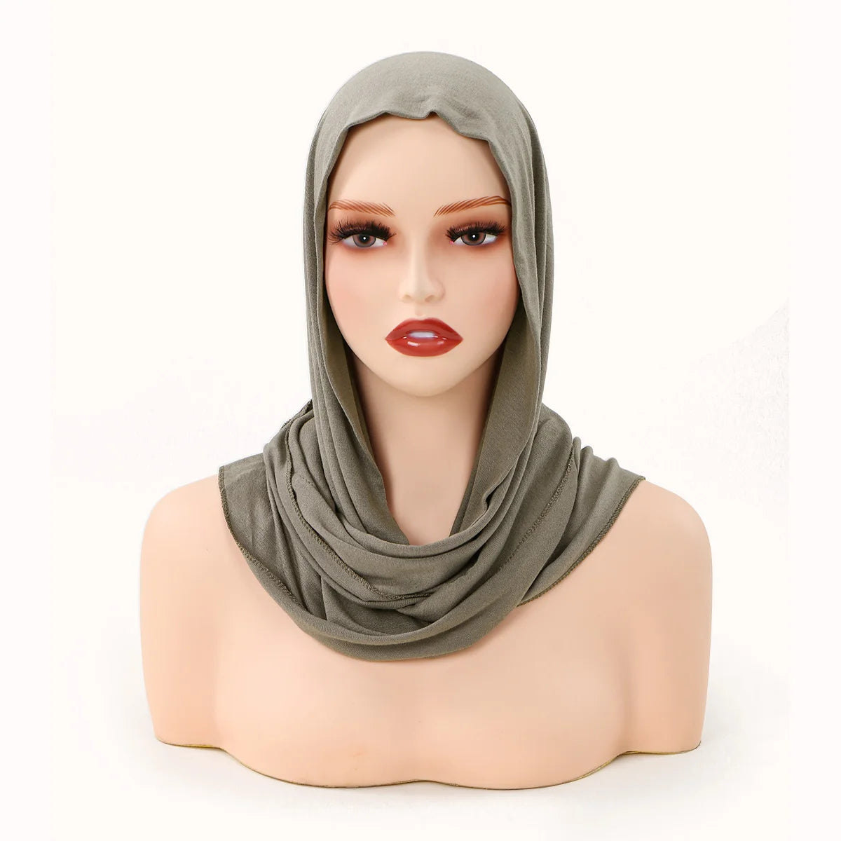 Model wearing an olive green jersey hijab scarf draped around her neck and head.