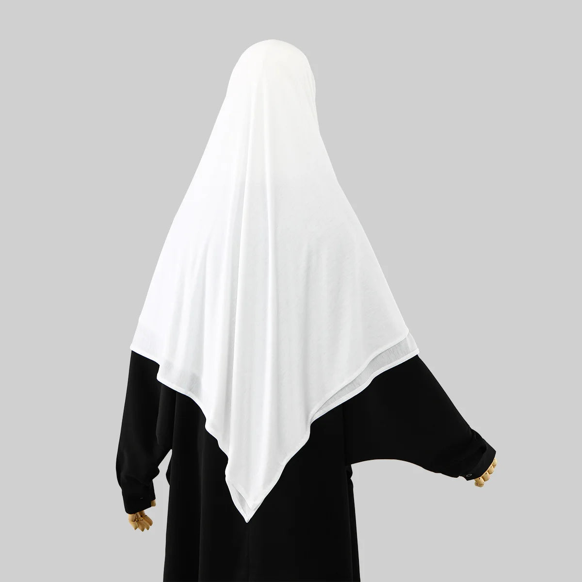 A woman wearing a white hijab and black clothing.