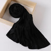 Black ribbed jersey hijab scarf draped over a light wooden frame.