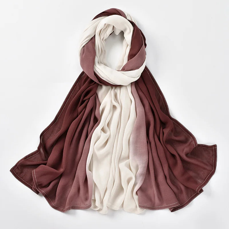 Un foulard hijab drapé avec un dégradé élégant de rose poudré et de crème.