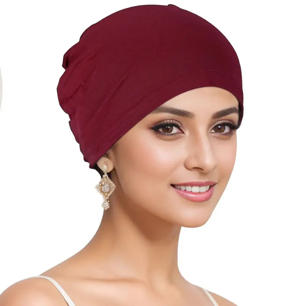 A model wearing a deep burgundy breathable cotton underscarf with an elastic fit.