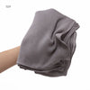 Écharpe châle en crinkle de rayon gris pliée, portée sur le bras d'une personne.