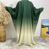 Robe islámica fluida verde esmeralda y amarillo pálido sobre fondo blanco.