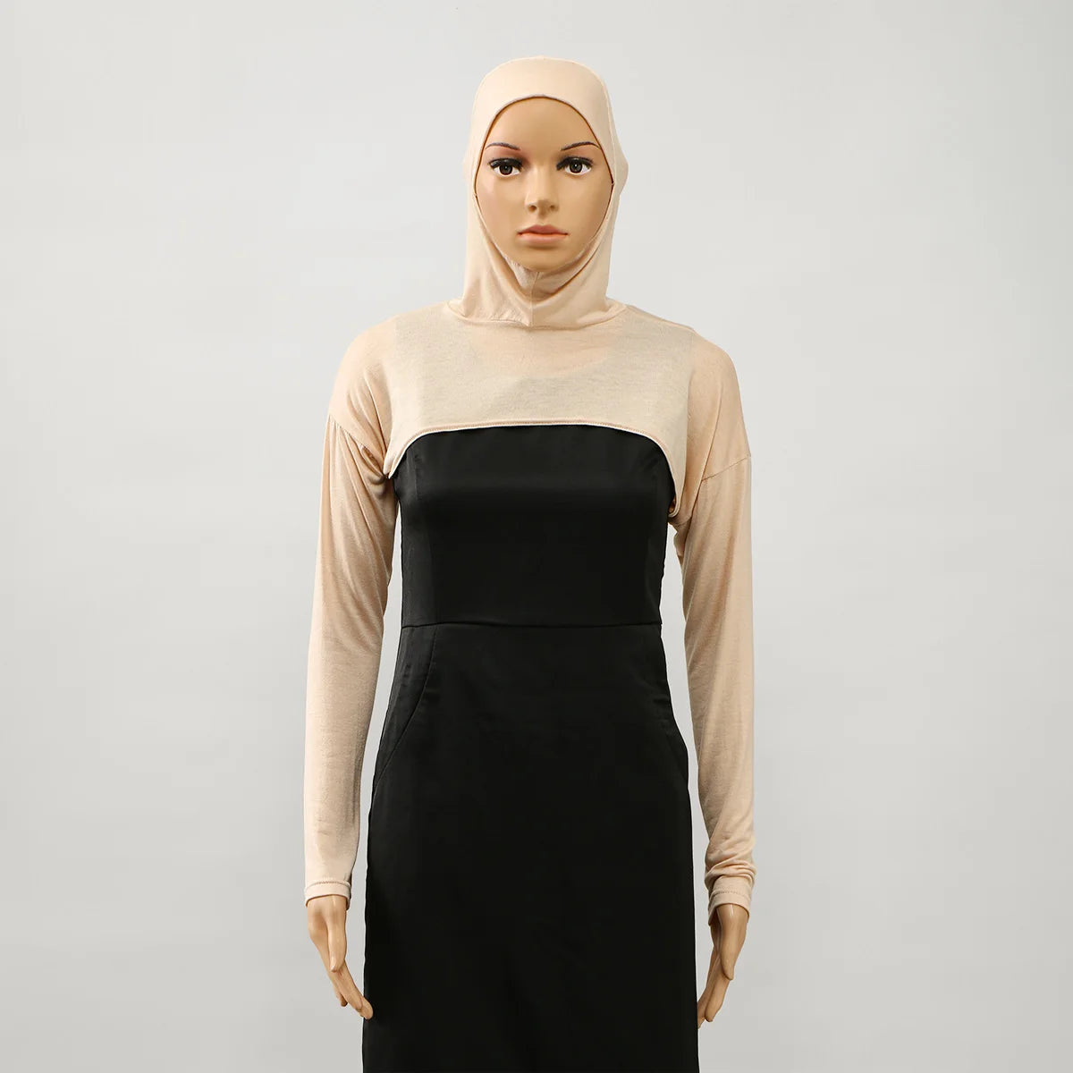 Model trägt eine beige elastische Modal-Jersey-Schulterjacke mit schwarzem Oberteil und Rock.