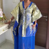 Model trägt ein traditionelles afrikanisches Dashiki Maxi-Kleid aus gold- und königsblauem Stoff mit plissierten Details.
