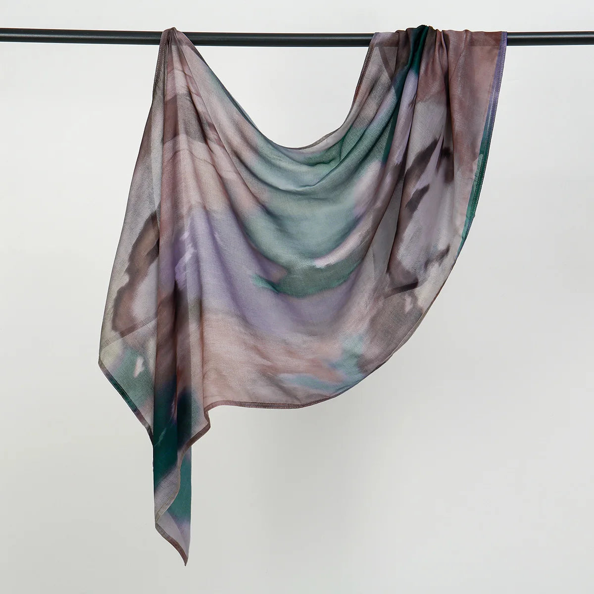 Fließender Aquarellschal in Mauve-, Grün- und Grautönen über einem Haken drapiert.